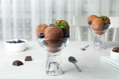 Glass bowl of chocolate ice cream served on light table