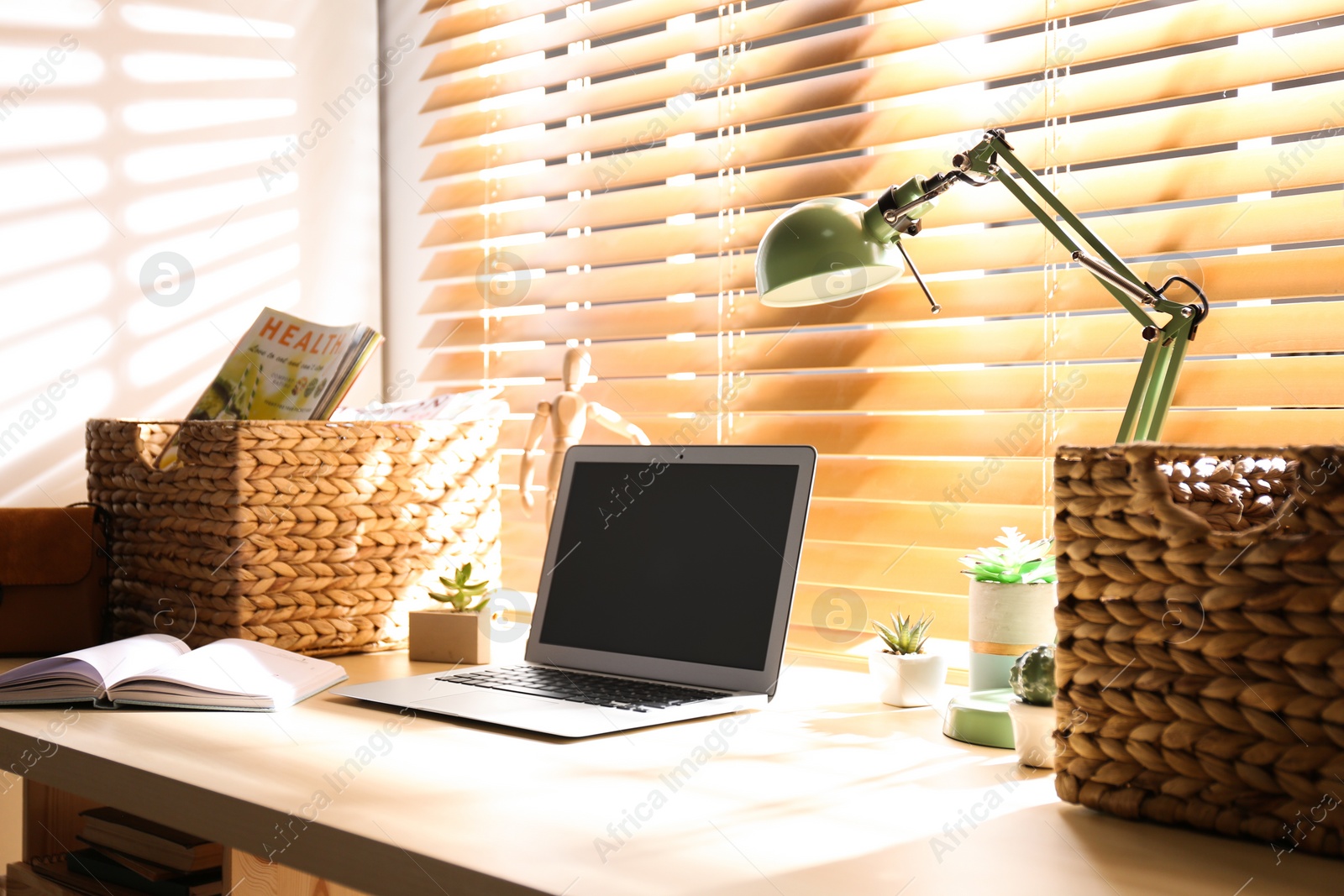 Photo of Comfortable workplace with laptop near window at home