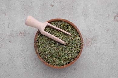 Photo of Bowl and scoop with dried thyme on grey table, top view