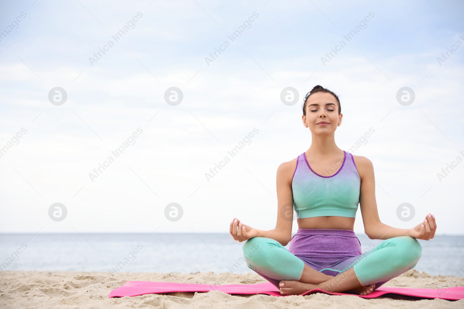 Photo of Young woman practicing yoga on beach, space for text. Body training