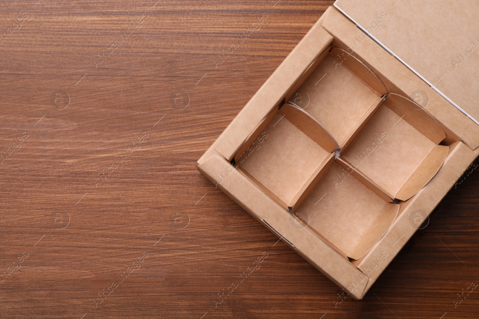 Photo of Empty candy box on wooden background, top view. Space for text