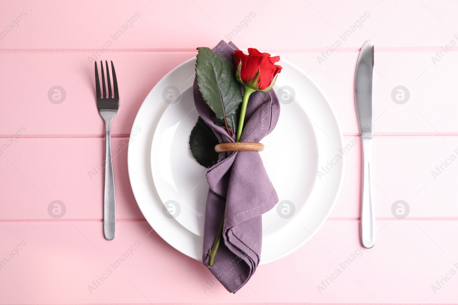 Photo of Beautiful table setting for romantic dinner on pink wooden background, flat lay. Valentine's day celebration