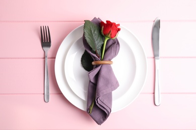 Photo of Beautiful table setting for romantic dinner on pink wooden background, flat lay. Valentine's day celebration