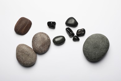 Many different stones on white background, top view