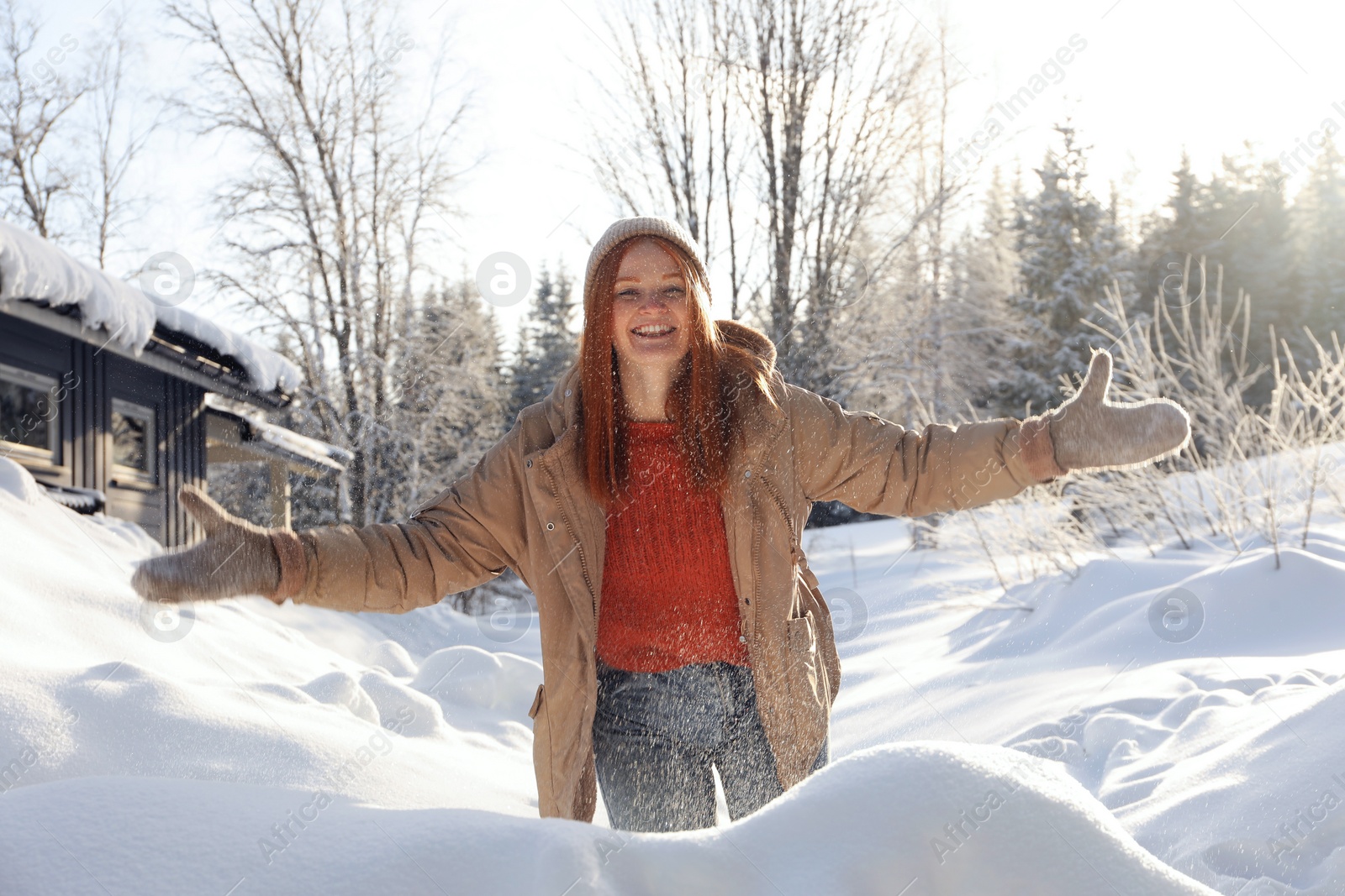 Photo of Happy woman playing with snow outdoors. Winter vacation