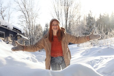 Photo of Happy woman playing with snow outdoors. Winter vacation