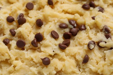 Photo of Raw dough for chocolate chip cookies as background, closeup