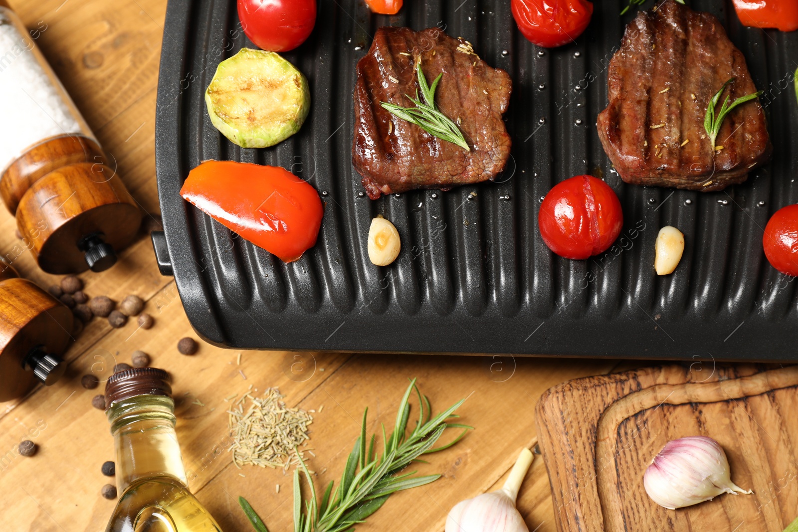 Photo of Flat lay composition with electric grill and different products on wooden table