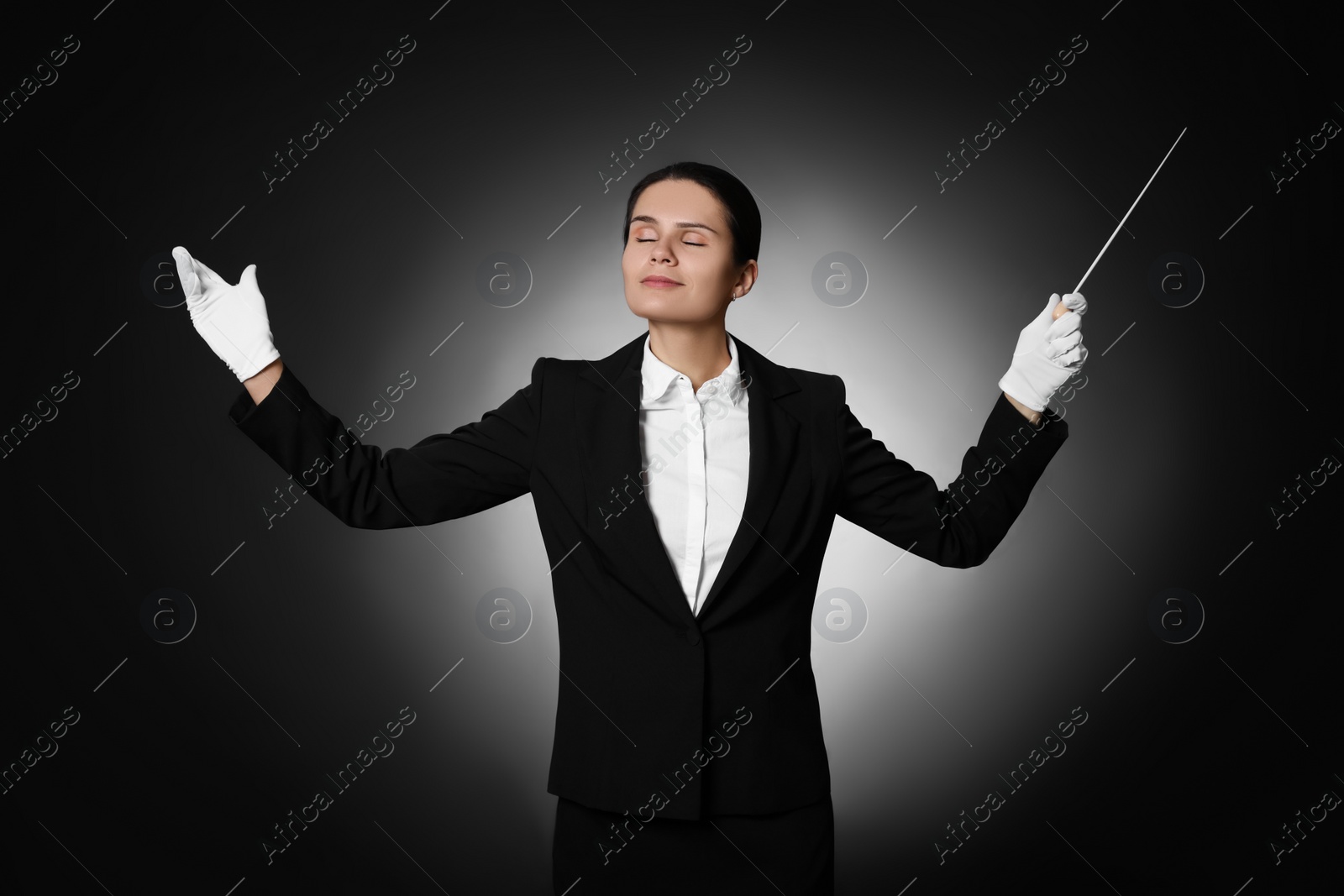 Photo of Professional conductor with baton on black background