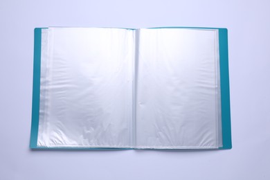 Photo of File folder with punched pockets and paper sheets isolated on white, top view