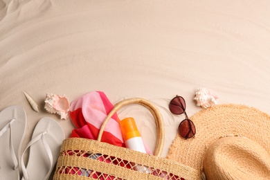 Different beach accessories on sand, flat lay. Space for text