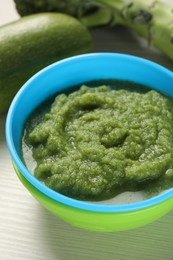 Photo of Healthy baby food. Bowl with tasty broccoli puree on white wooden table