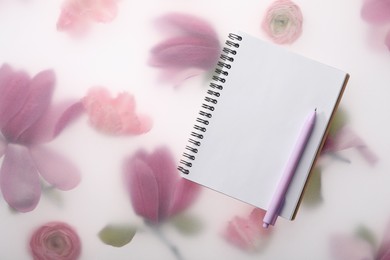 Photo of Guest list. Notebook and pen on spring floral background, flat lay. Space for text