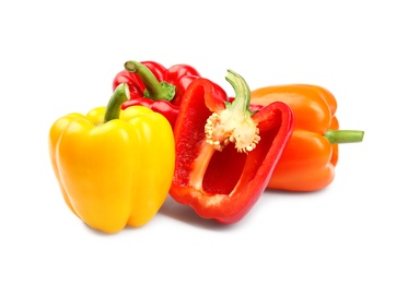 Whole and cut bell peppers on white background