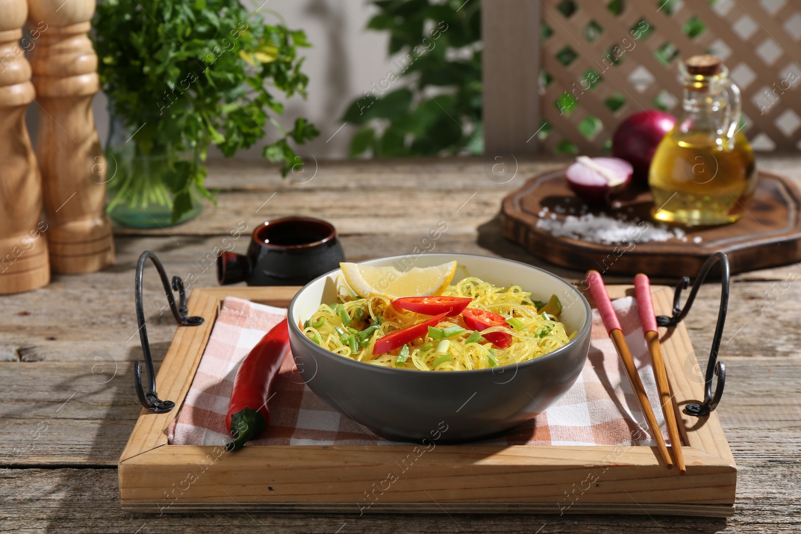 Photo of Stir-fry. Tasty noodles with vegetables and meat in bowl served on wooden table