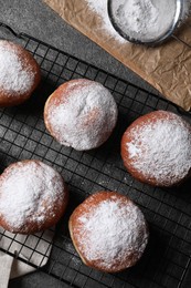 Delicious sweet buns, powdered sugar and strainer on table, flat lay