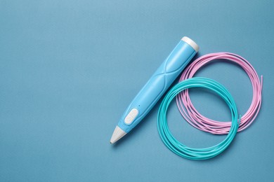 Photo of Stylish 3D pen and colorful plastic filaments on light blue background, flat lay. Space for text