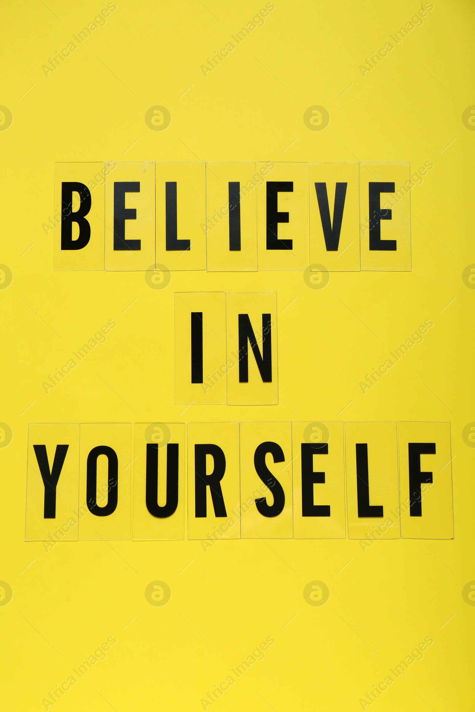 Photo of Phrase Believe In Yourself and hearts on yellow background, top view. Motivational quote