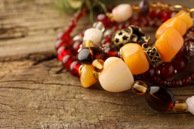 Photo of Beautiful bracelets with gemstones on wooden surface, closeup, Space for text
