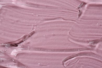 Clear cosmetic serum on pink background, macro view