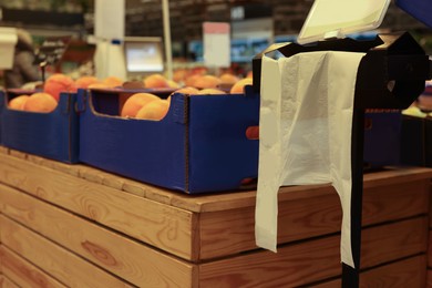 Photo of Plastic bags near boxes with fruits in supermarket