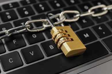 Photo of Cyber security. Padlock with chain on laptop, closeup