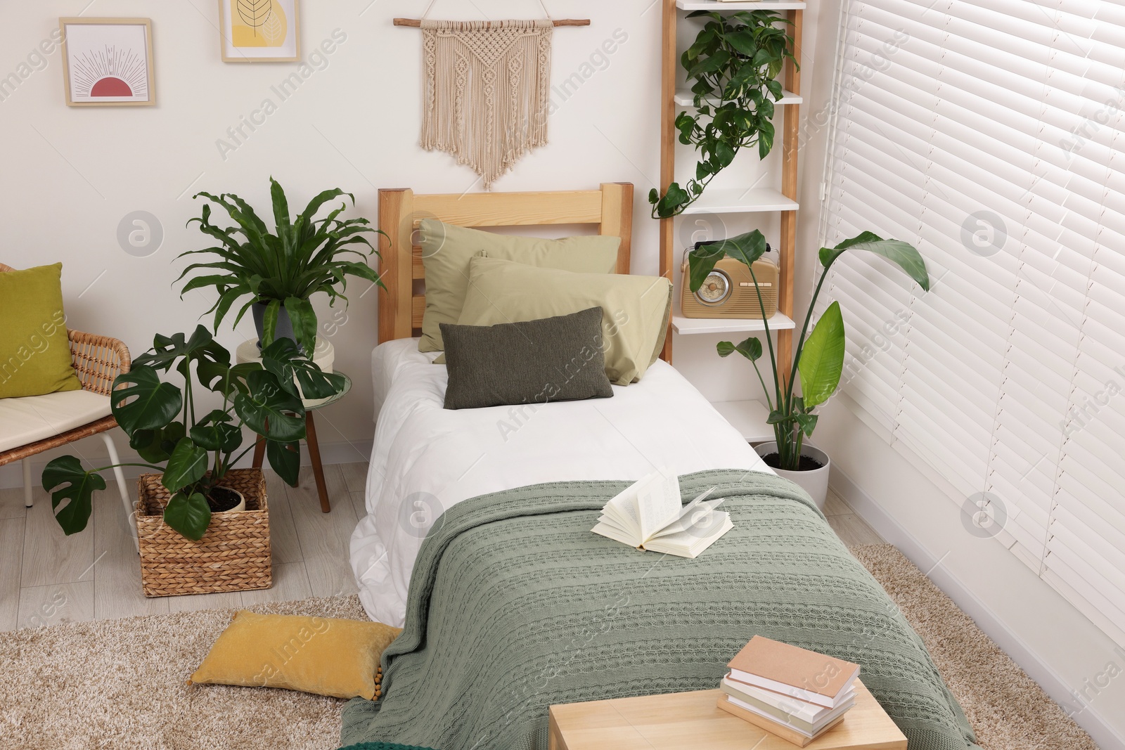 Photo of Large comfortable bed and potted houseplants in stylish bedroom. Interior design