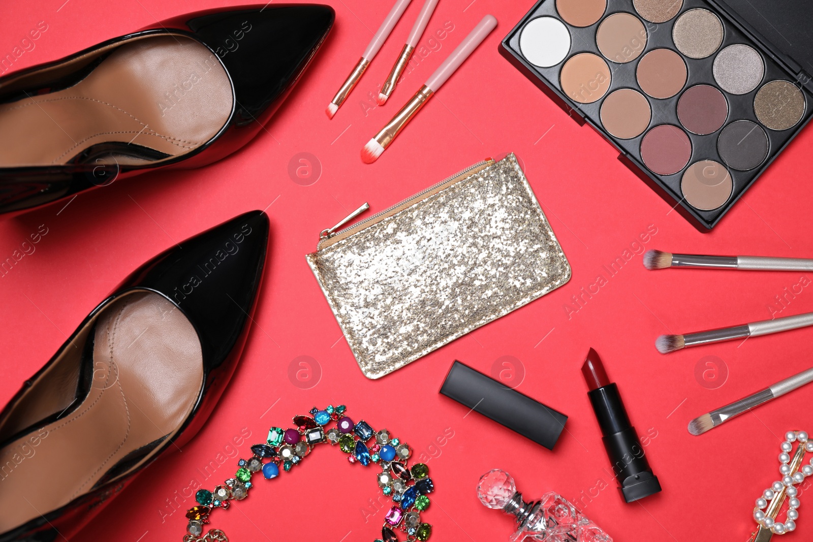 Photo of Flat lay composition with women's shoes, cosmetics and accessories on red background