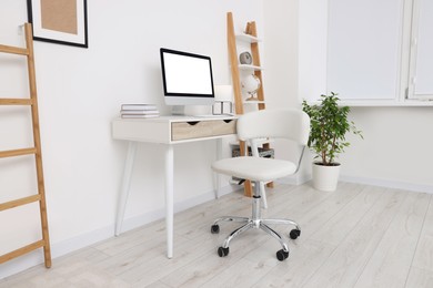 Photo of Workplace with comfortable office chair indoors. Interior design