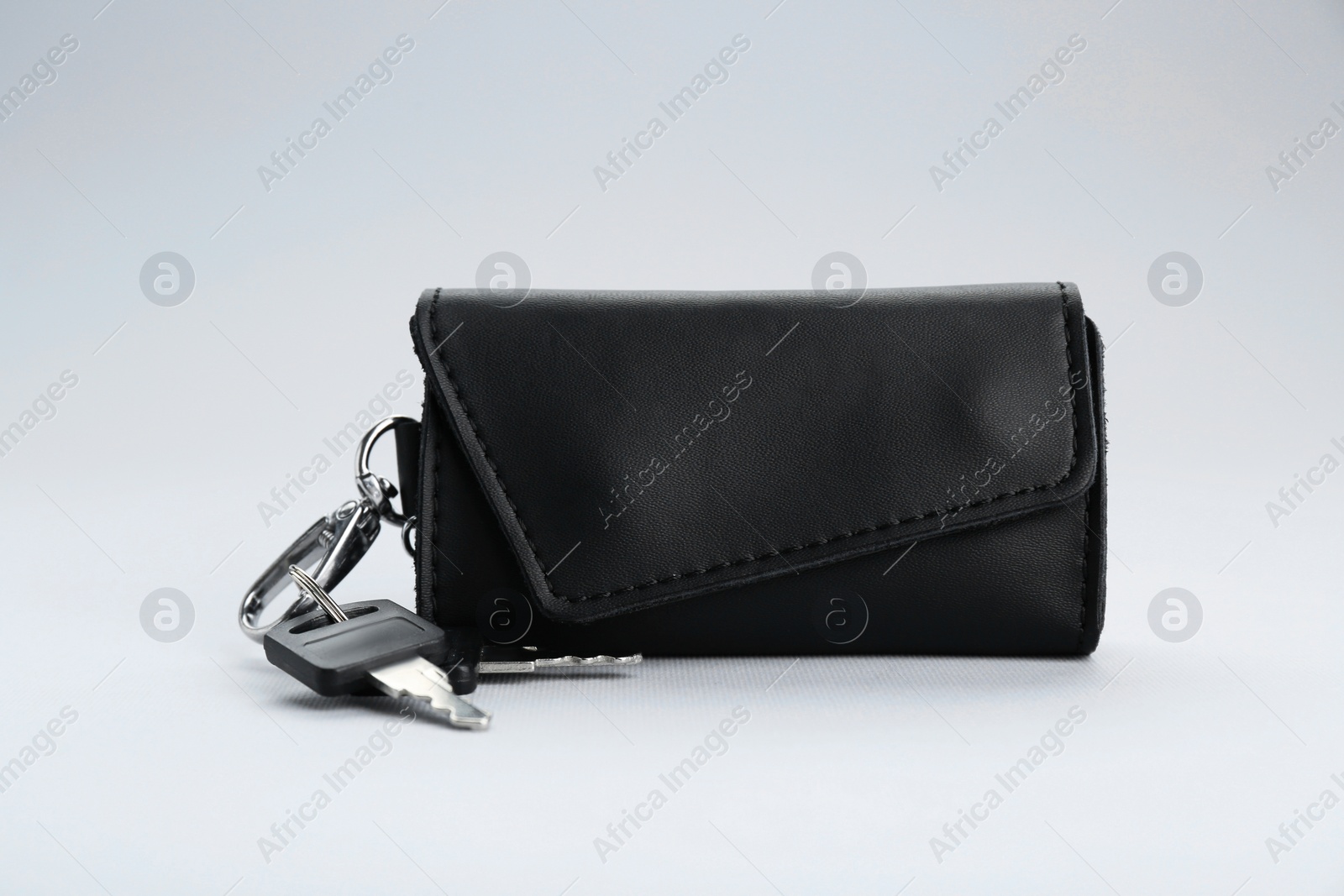 Photo of Leather case with keys on light grey background