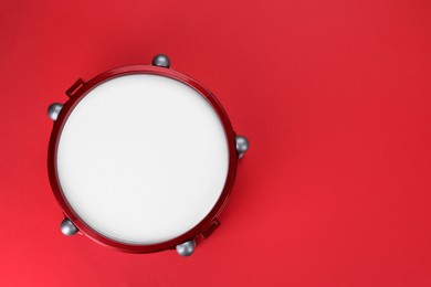 Photo of Drum on red background, top view with space for text. Percussion musical instrument