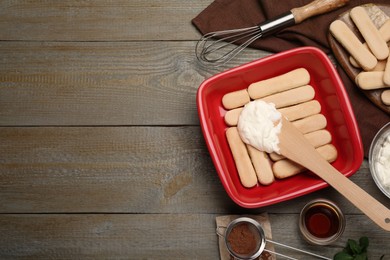 Photo of Flat lay composition with different tiramisu ingredients on wooden table, space for text