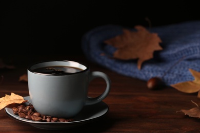 Photo of Composition with cup of hot cozy drink and autumn leaves on table. Space for text