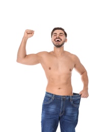 Photo of Fit man in oversized jeans on white background. Weight loss