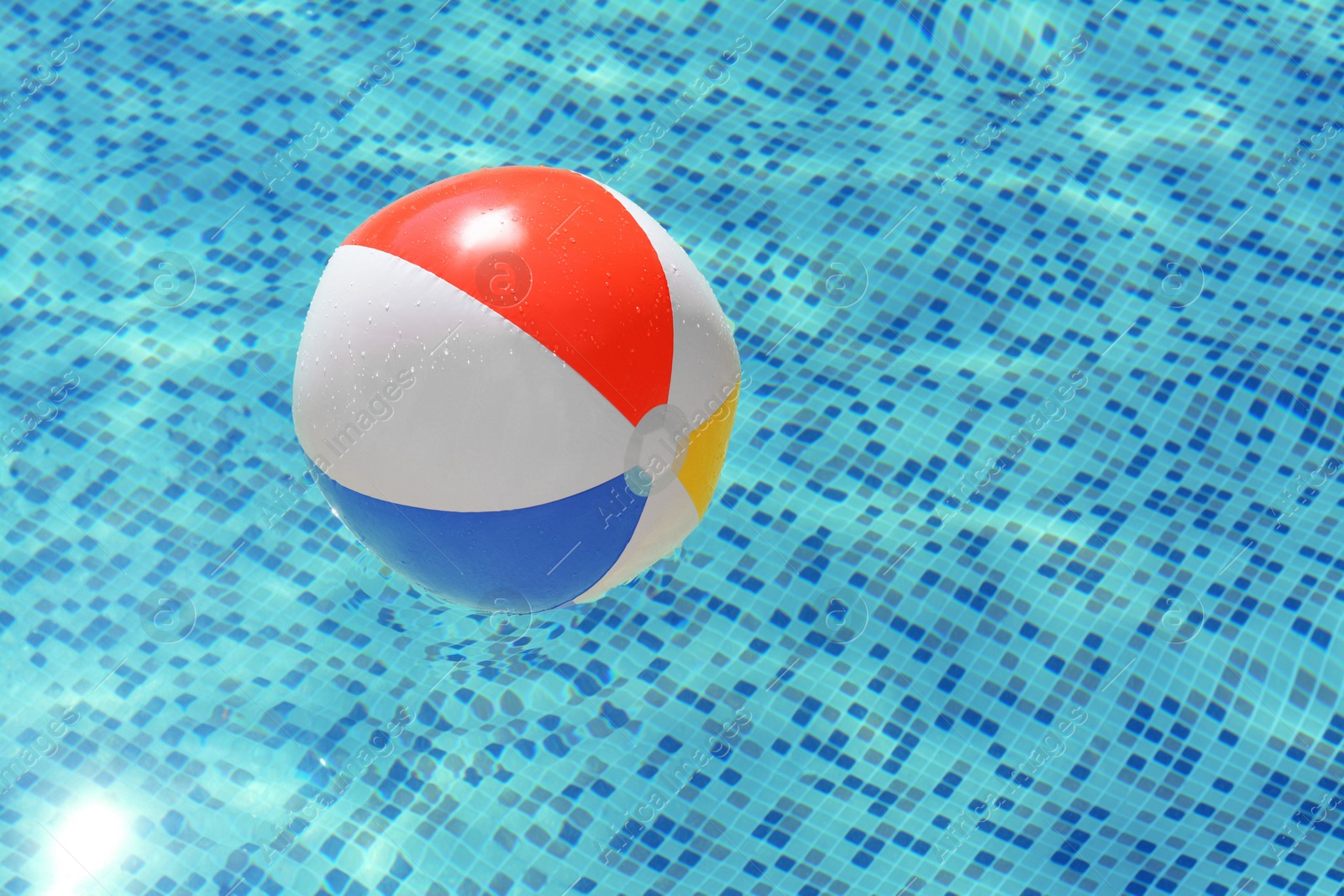 Photo of Inflatable beach ball floating in swimming pool, space for text