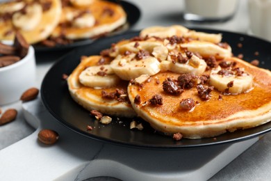 Photo of Tasty pancakes with sliced banana served on table, closeup
