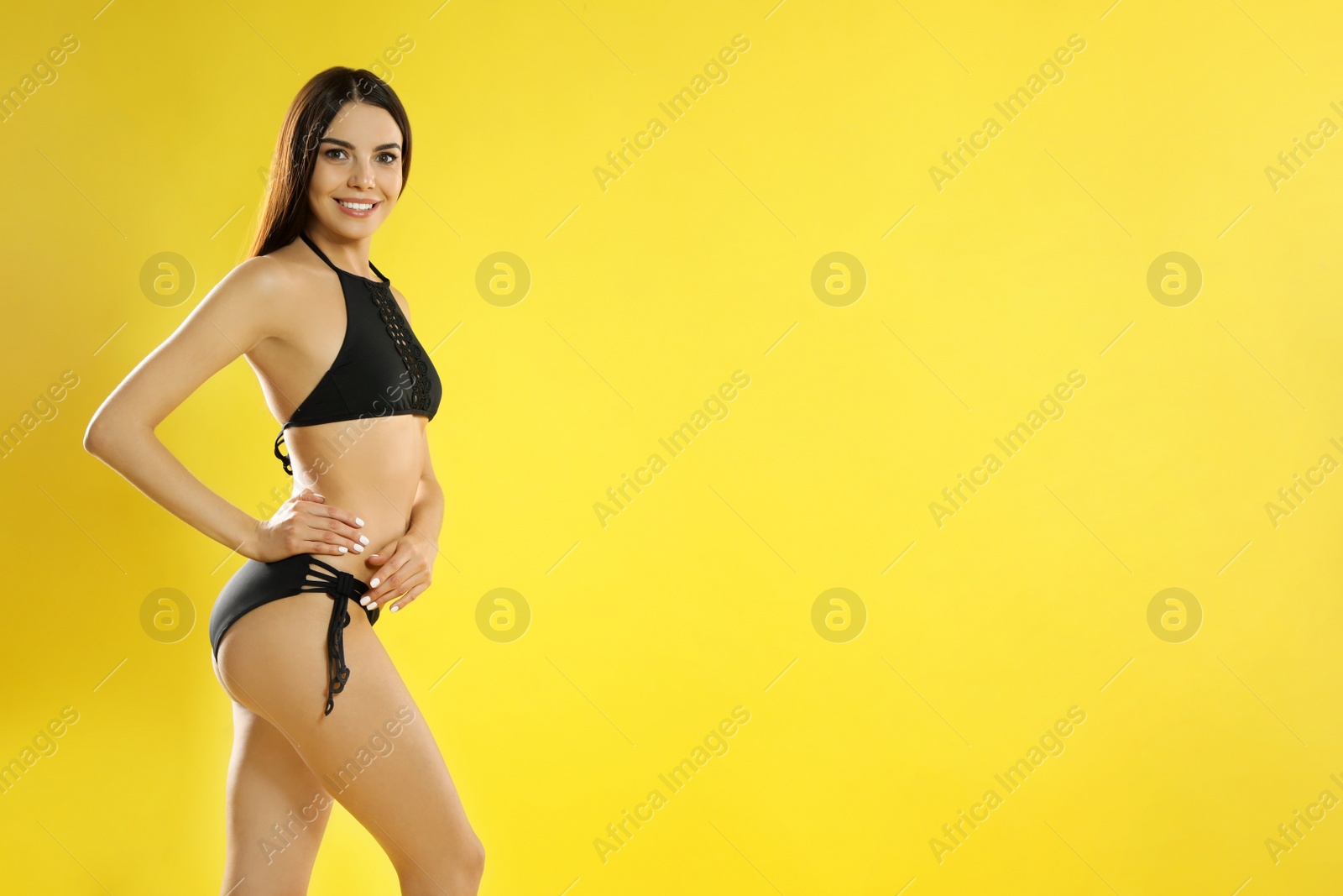 Photo of Portrait of attractive young woman with slim body in swimwear on color background. Space for text