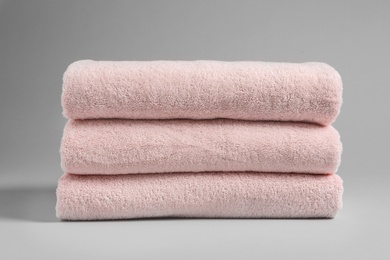 Photo of Stack of fresh towels on light background