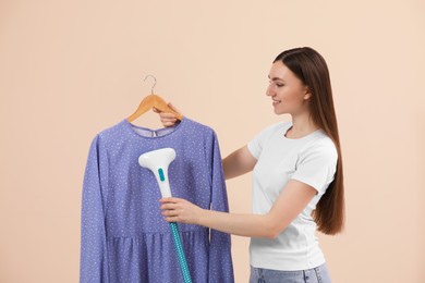 Photo of Woman steaming blouse on hanger against beige background