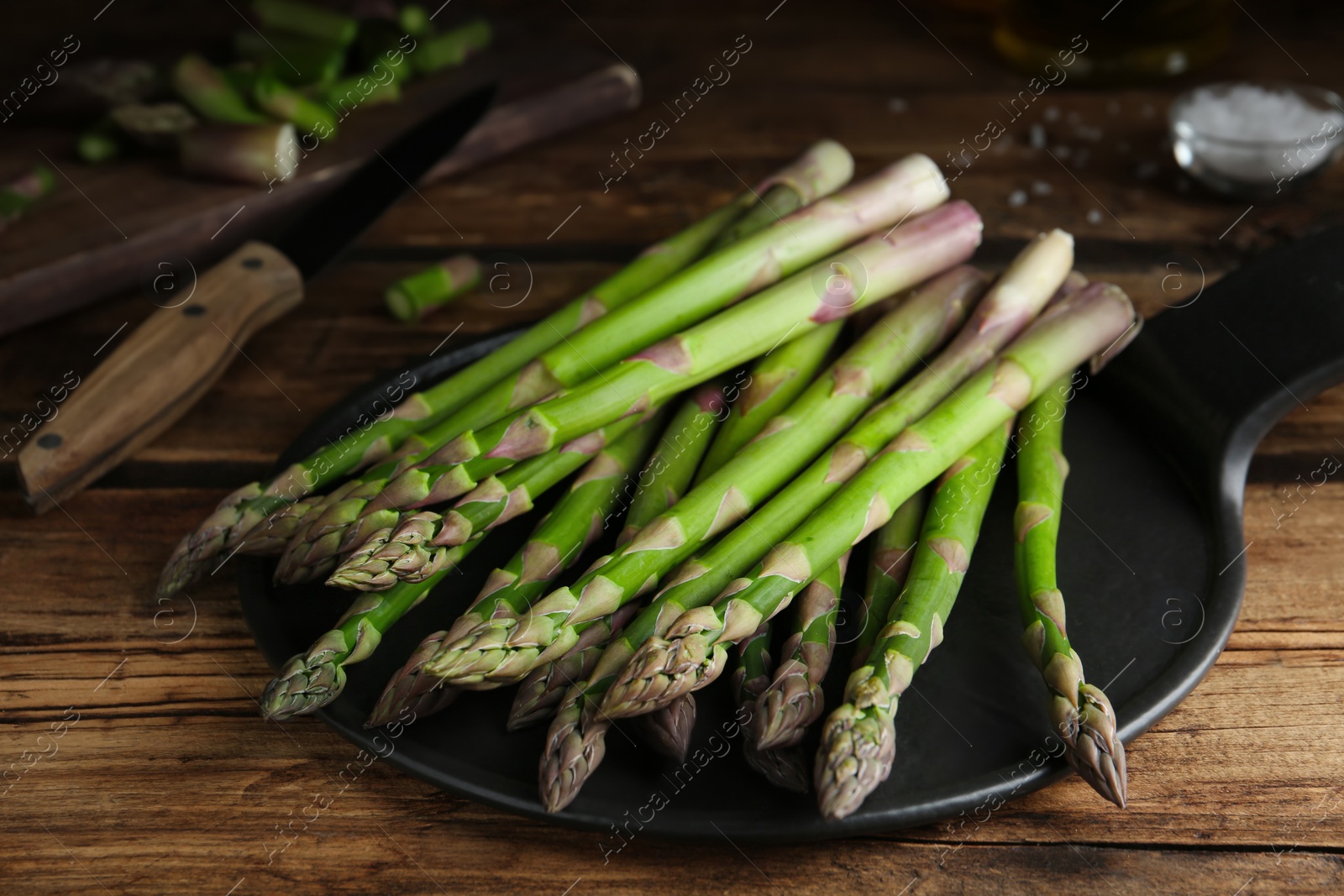 Photo of Fresh raw asparagus on wooden table, closeup