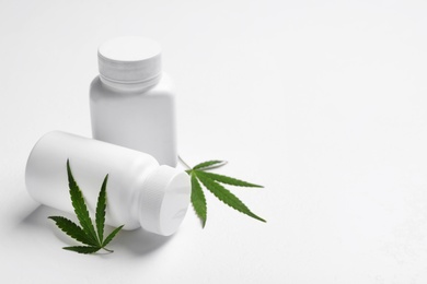 Photo of Hemp leaves and pill bottles on white background. Space for text