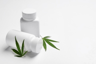 Hemp leaves and pill bottles on white background. Space for text