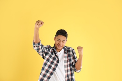 Photo of Portrait of emotional African-American teenage boy on color background