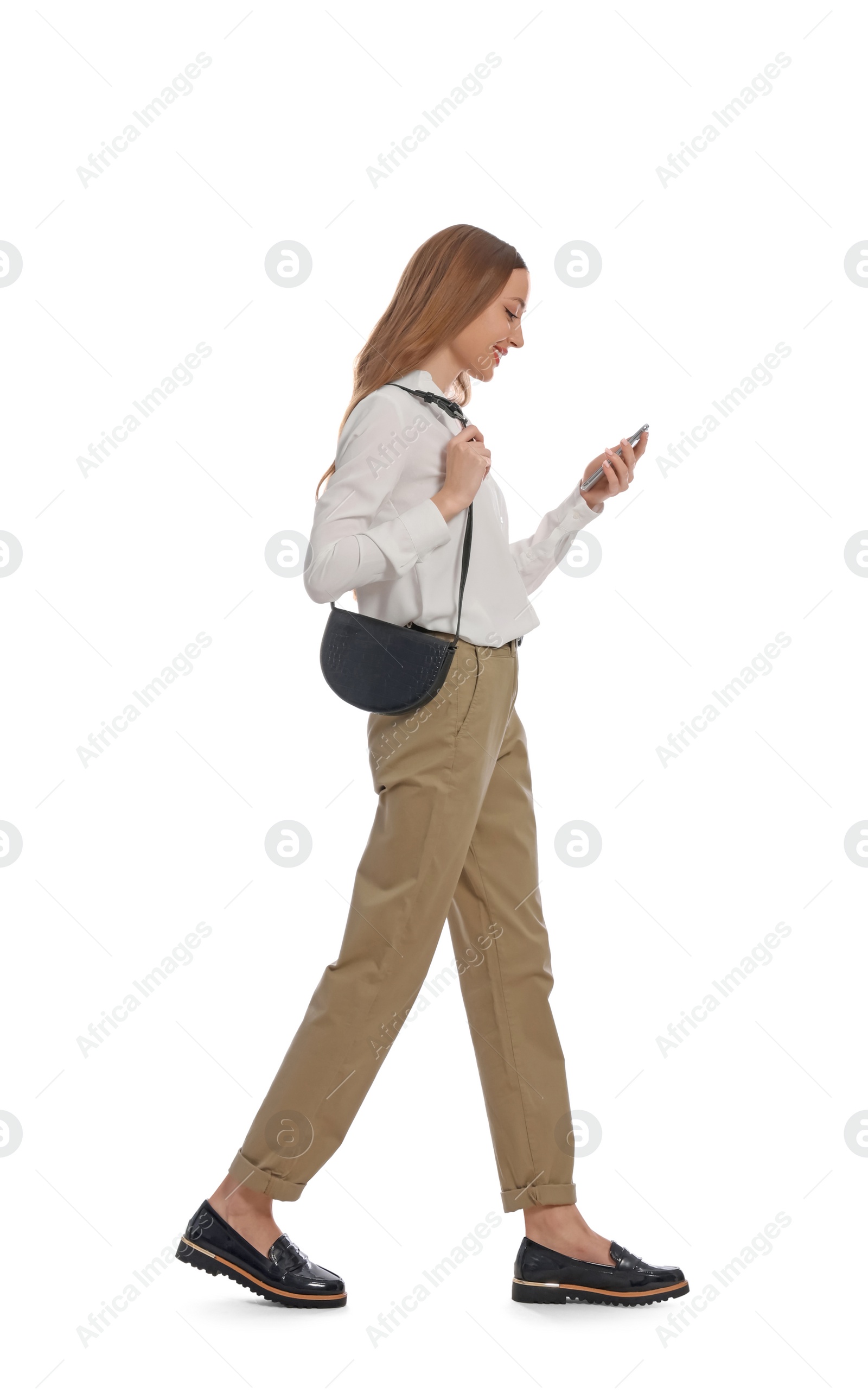 Photo of Young woman using smartphone while walking on white background