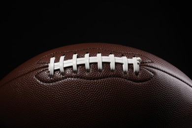 Photo of American football ball on black background, closeup