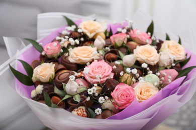 Photo of Beautiful food bouquet of sweets and flowers on light background