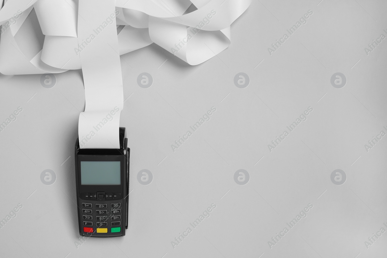 Photo of Payment terminal with thermal paper for receipt on light grey background, top view. Space for text