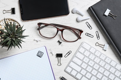 Photo of Flat lay composition with office items and glasses on wooden table