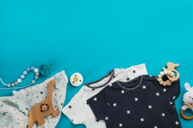 Flat lay composition with baby clothes and accessories on light blue background, space for text