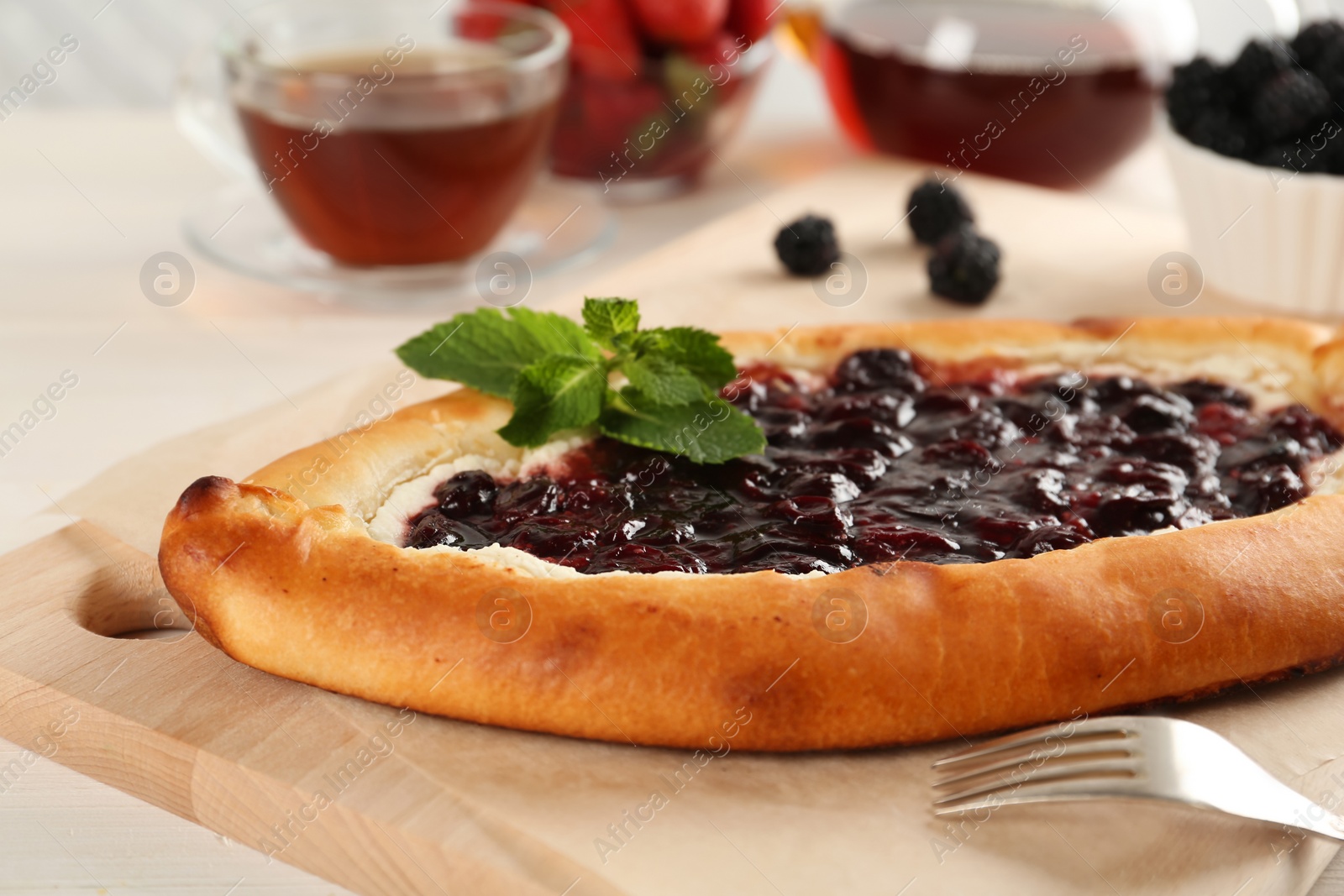 Photo of Delicious sweet cottage cheese pastry with cherry jam served on white table, closeup